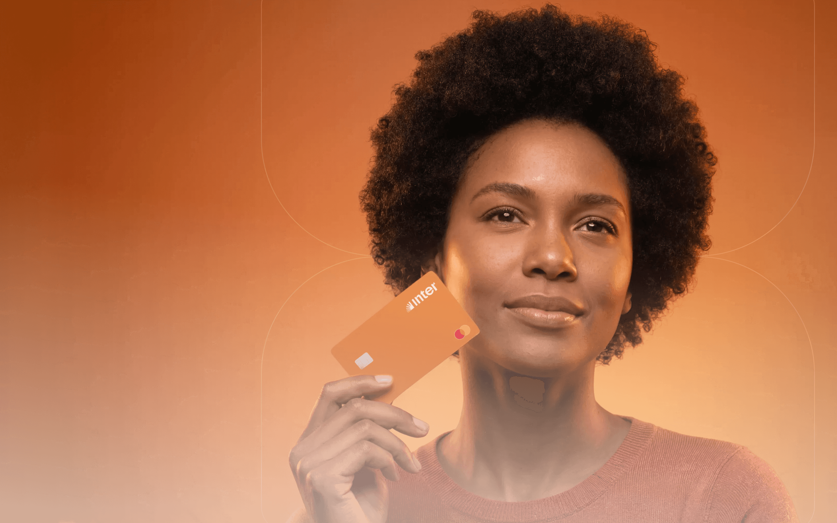 Mulher sorrindo segurando um cartão do Banco Inter